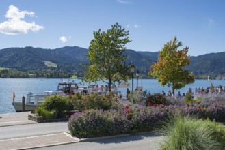 Jetty at Tegernsee, tourists on the promenade, flower beds in the foreground, town of Tegernsee,