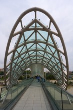 Modern, accessible bridge with glass roof and geometric pillars, Peace Bridge, Tbilisi, Kura River,