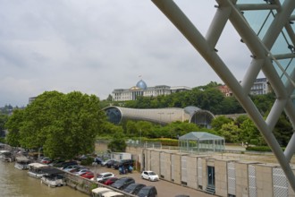 View from the riverbank of modern buildings and dome with boats in the foreground, view from the