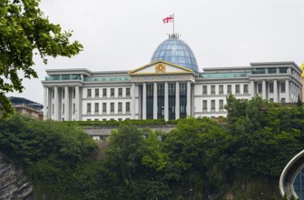 Large government building with dome and flag on a green hill, state palace for ceremonies, Avlabari
