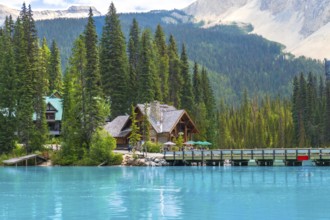 Wooden houses of emerald lake lodge resting on the shore of stunning emerald lake, surrounded by