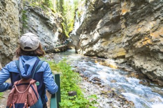 Female tourist with a backpack admiring the turquoise waters of bow river flowing through johnston