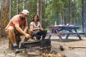 Tourists are grilling food for lunch over a campfire in a campsite in banff national park, canadian