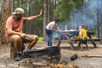 Family camping and grilling while bonding in the breathtaking scenery of banff national park, with