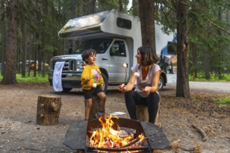 Mother and son roasting marshmallows over a campfire, enjoying quality time together during a