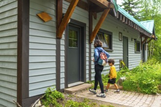 Mother and son leaving their cabin at emerald lake lodge, yoho national park, british columbia,
