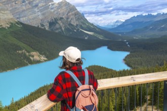 Young hiker enjoying breathtaking view of turquoise peyto lake from a scenic viewpoint in banff