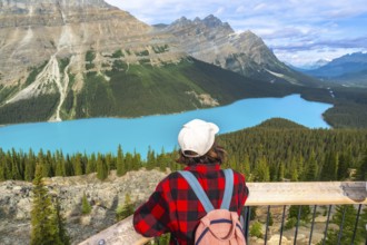Tourist with a backpack enjoying breathtaking views of vibrant turquoise waters at peyto lake,