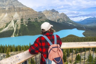Young hiker admiring stunning turquoise color of peyto lake from viewpoint in banff national park,