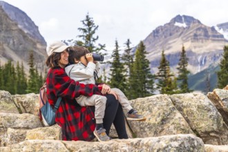 Mother and son are enjoying a scenic view at peyto lake in banff national park, with the boy using