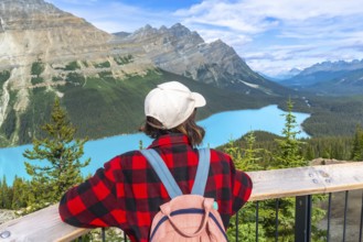 Female tourist with backpack and baseball cap enjoying breathtaking panoramic view of turquoise