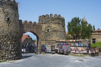 Stone gate with colorful souvenir stands and surroundings in a historic city, city gate, entrance