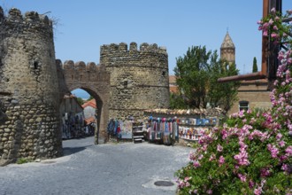 Historic stone gate with stalls and flowers in the foreground, city gate, entrance to the old town,