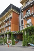 Multi-storey residential building with colorful facades, balconies and lots of greenery, Brim