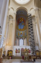 The interior of a church with tall columns, frescoes and an impressive altar, Sameba Cathedral,
