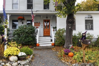 Typical American house in autumn, white wooden house with porch and front garden, guest room,