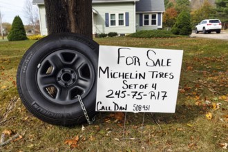 Michelin tires for off-road vehicles chained to tree sign for sale curbside front garden Ogunquit