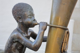 Sculpture boy with tuba by Guido Messer 1991, modern art, bronze sculpture, playing music, tuba,
