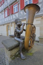 Sculpture boy with tuba by Guido Messer 1991, modern art, bronze sculpture, playing music, tuba,