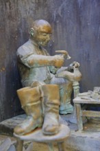 Shoemaker making shoes at Bonifatius Stirnberg's guild fountain 1983, modern art, bronze sculpture,
