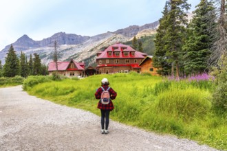 Female tourist walking along a gravel path toward the historic num ti jah lodge at bow lake,