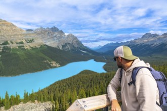 Hiker enjoying breathtaking view of turquoise peyto lake and surrounding canadian rockies mountains