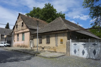 Two old houses with tiled roofs and weathered facades on a cobblestone street, traditional German