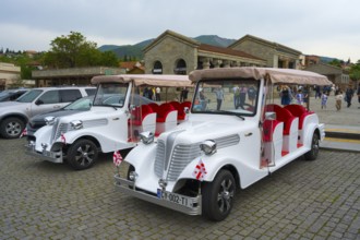 Nostalgic electric vehicles with Georgian flags for tourists in an old town, Mtskheta Square,