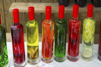 Close-up of colorful bottles filled with pickled fruits, chacha with colorful fruits, vegetables or