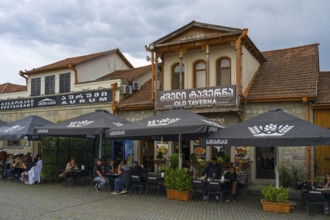 A cozy tavern with outdoor seating and lots of umbrellas, ideal for social gatherings, houses on