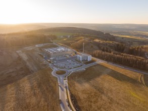 View of industrial plant and hilly landscape in evening light, future PV building on old deposit,