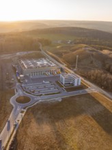 Industrial plant next to hilly landscape at sunset, future PV building on old deposit, Lindenrain