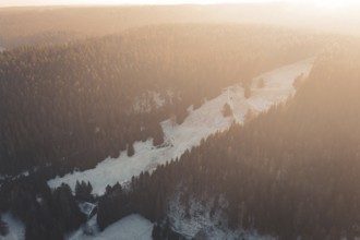 Snowy mountain landscape at sunset surrounded by thick forests, Enzklösterle, Calw district,