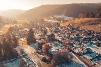 Aerial view of a small village in winter nestled in a hilly landscape at sunset, Enzklösterle, Calw