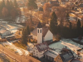 Close-up of a church in a small, snowy village surrounded by trees and a peaceful ambiance,