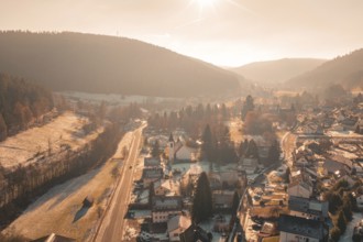 A snowy village with a church, surrounded by thick forests and bright skies, Enzklösterle, Calw