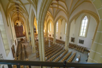 View from the gallery over the church interior with Gothic arched windows and detailed columns,