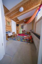 Colourful children's room with toys, wooden elements and carpet that radiates a cozy atmosphere,