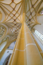 Detailed view of an interior ceiling with Gothic vault and massive columns in a wide nave,
