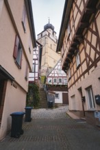 Charming old town street with half-timbered houses and small shops, collegiate church, Herrenberg,