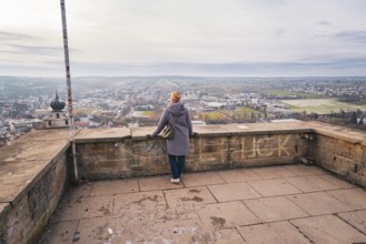 Woman standing on a viewing platform and enjoying the wide view over the city, Herrenberg,