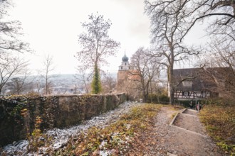 Winter trail with a view of a church tower and landscape, surrounded by bare trees, Herrenberg,