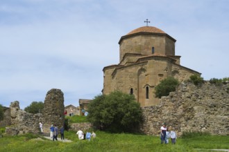 Old church and ruins in green landscape with people outdoors, Javari Monastery, Jvari Monastery,