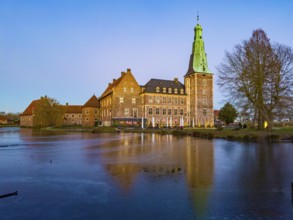 View in winter over partially frozen moat at castle converted into a Renaissance castle today