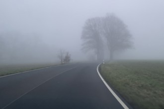 Driver's perspective view of foggy, foggy country road in thick fog in winter, Germany