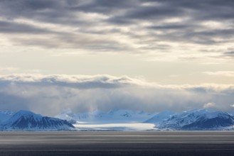 Glaciers between snow-capped mountains at sea, clouds, Longyearbyen, Spitsbergen, Svalbard