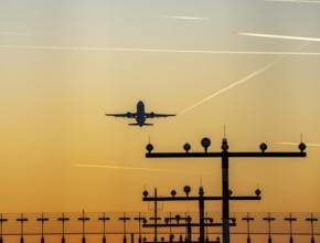 Runway lighting, approach aids, at Düsseldorf International Airport, sunset, aircraft taking off,