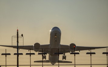 Runway lighting, approach aids, at Düsseldorf International Airport, sunset, aircraft taking off,