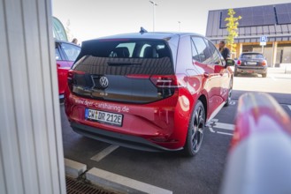 Red Volkswagen car sharing car in parking lot, modern design and urban environment, ID3, Deer e-