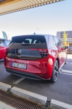 Red Volkswagen car sharing car in parking lot with urban atmosphere and modern design, ID3, Deer